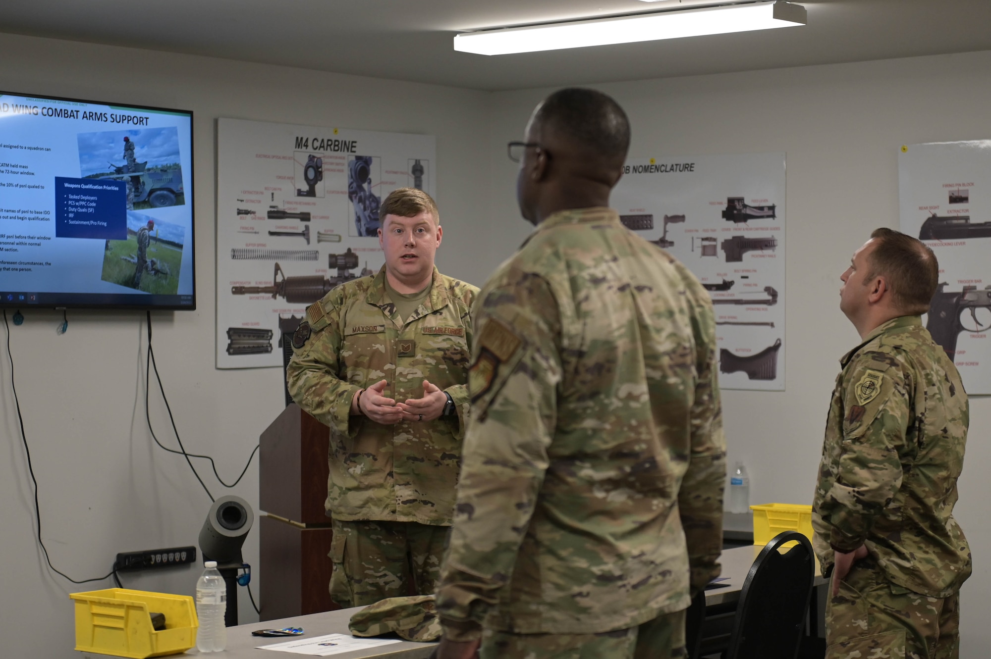 U.S. Air Force Tech. Sgt. Jeffrey Maxson, 23rd Security Forces Squadron noncommissioned officer in charge of combat arms, left, briefs Maj. Gen. Stacey Hawkins, Air Combat Command director of logistics, engineering and force protection, middle, and Chief Master Sgt. Lester Braithwaite, ACC A4 senior enlisted leader, right, about their initiatives to support Lead-Wing concepts March 24, 2022, at Moody Air Force Base, Georgia. The 23rd SFS is streamlining the way the combat arms staff trains and qualifies Immediate Response Force assigned personnel. (U.S. Air Force photo by Senior Airman Rebeckah Medeiros)