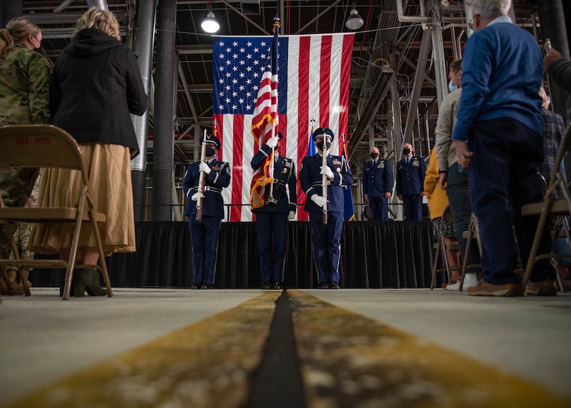 Ceremonial color guard stands in front of a stage
