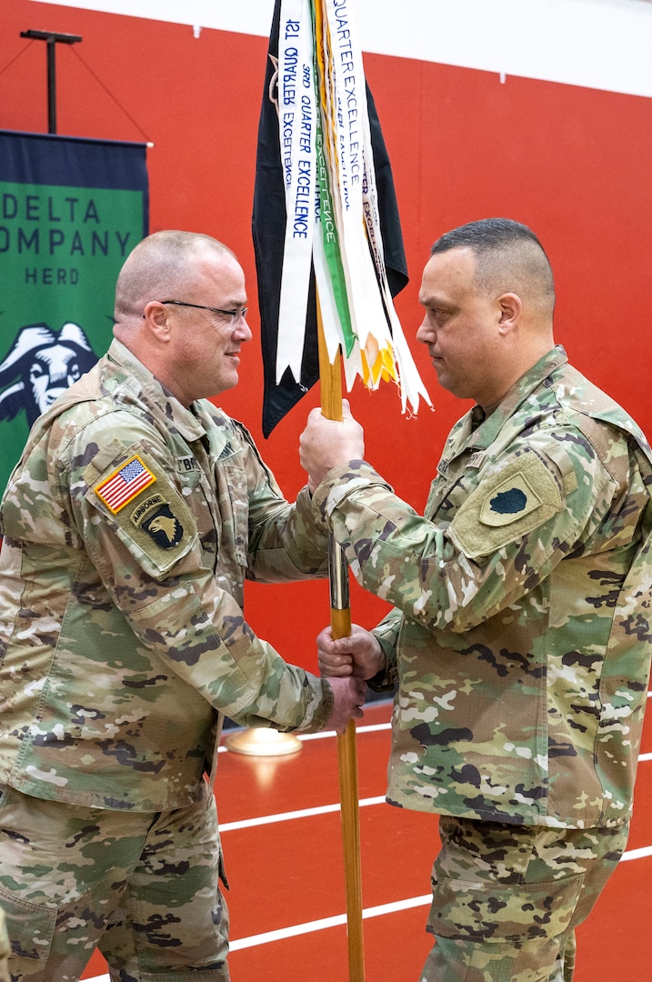 Command Sgt. Maj. Johnny J. O’Brien, of Sherman, Illinois, passes the Company D guidon to 1st Sgt. Dennis Medina of Chicago, Illinois, during a change of responsibility ceremony at the National Guard Armory in Aurora, Illinois, March 26.