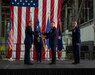 Four Airmen on stage passing around the organizational colors.