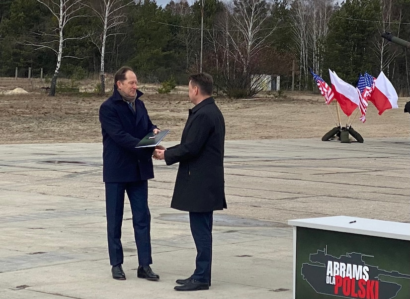 U.S. Ambassador to Poland Mark Brzezinski accepts the signed Foreign Military Sales case from Polish Minister of National Defence Mariusz Błaszczak for the purchase of Abrams tanks and other equipment at a ceremony in Wesola, Poland, April 5.