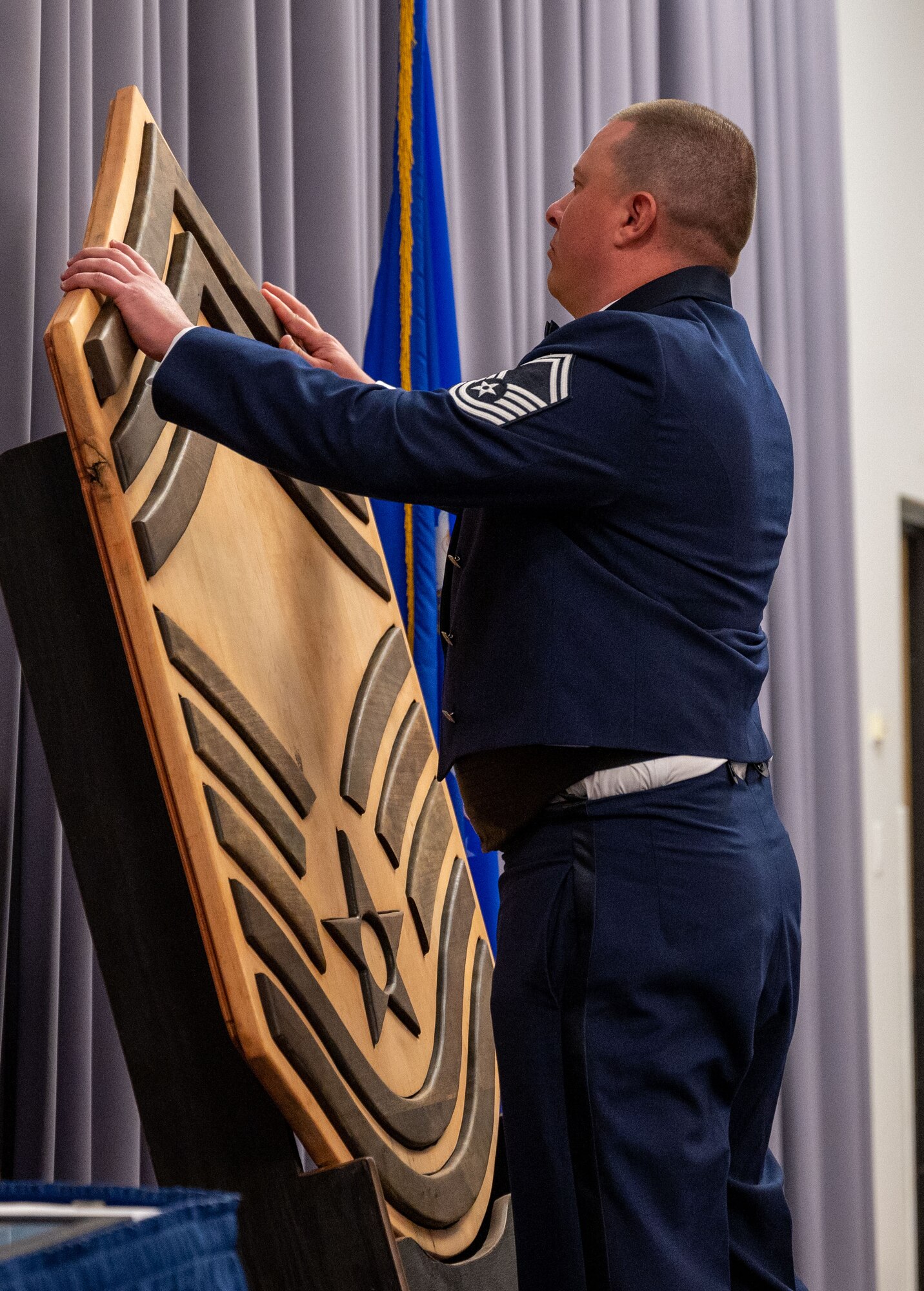 Senior Master Sgt. Ricardo A. Visconti, 436th Logistics Readiness Squadron fuels flight chief, places the final chevron on a wooden cut out of the chief master sergeant rank during the 2022 Chief Induction ceremony at Dover Air Force Base, Delaware, April 2, 2022. The rank of chief master sergeant is the highest enlisted rank in the Air Force, with only one percent of the enlisted force structure reaching it.  (U.S. Air Force photo by Airman 1st Class Cydney Lee)
