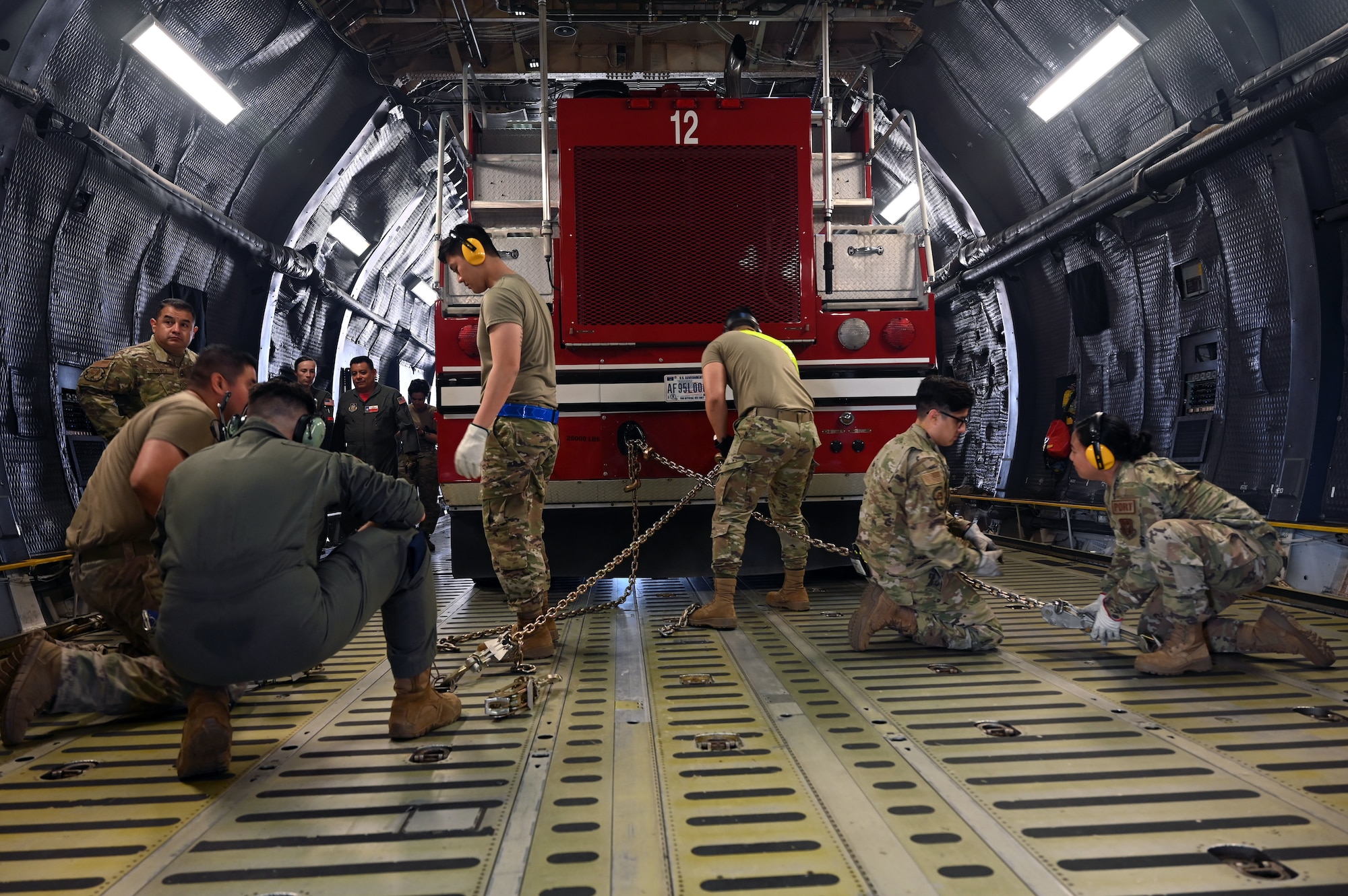 Reserve Citizen Airmen in the 74th Aerial Port Squadron work with 433rd Airlift Wing C-5M Super Galaxy aircrew to practice the on-load and offload of a firetruck April 3, 2022, Joint Base San Antonio-Lackland, Texas. (U.S. Air Force photo by Staff Sgt. Monet Villacorte)