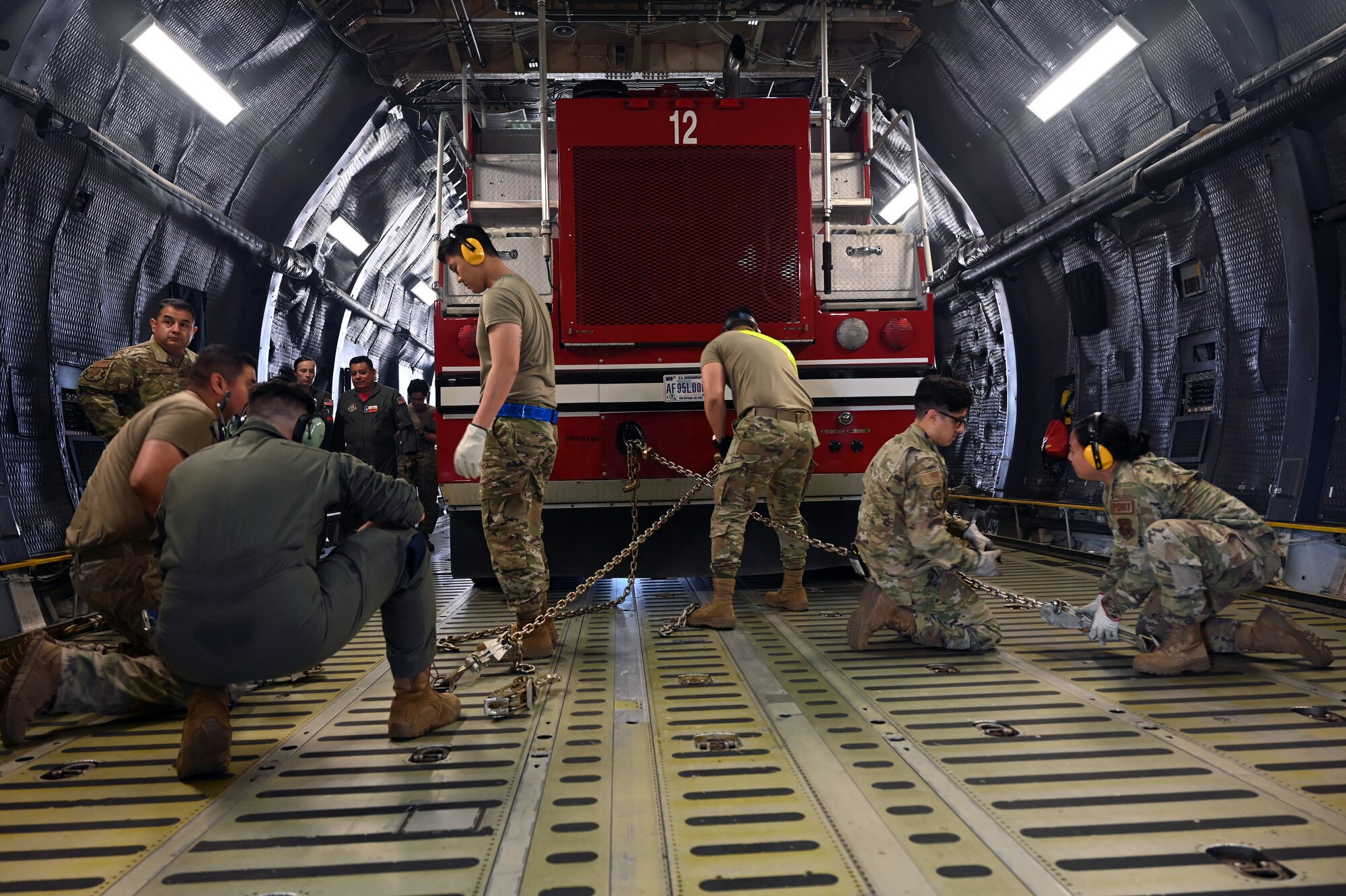 Reserve Citizen Airmen in the 74th Aerial Port Squadron work with 433rd Airlift Wing C-5M Super Galaxy aircrew to practice the on-load and offload of a firetruck April 3, 2022, Joint Base San Antonio-Lackland, Texas. (U.S. Air Force photo by Staff Sgt. Monet Villacorte)