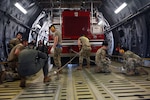 Reserve Citizen Airmen in the 74th Aerial Port Squadron work with 433rd Airlift Wing C-5M Super Galaxy aircrew to practice the on-load and offload of a firetruck April 3, 2022, Joint Base San Antonio-Lackland, Texas. (U.S. Air Force photo by Staff Sgt. Monet Villacorte)