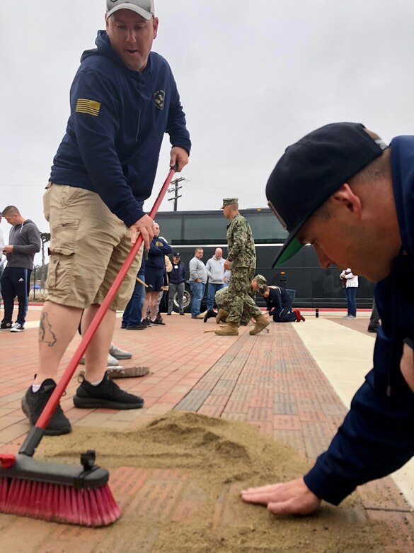 Volunteers from Center for Seabees and Facilities Engineering Chiefs Mess, and instructors and students from the Naval Construction Training Center Port Hueneme install commemorative bricks.