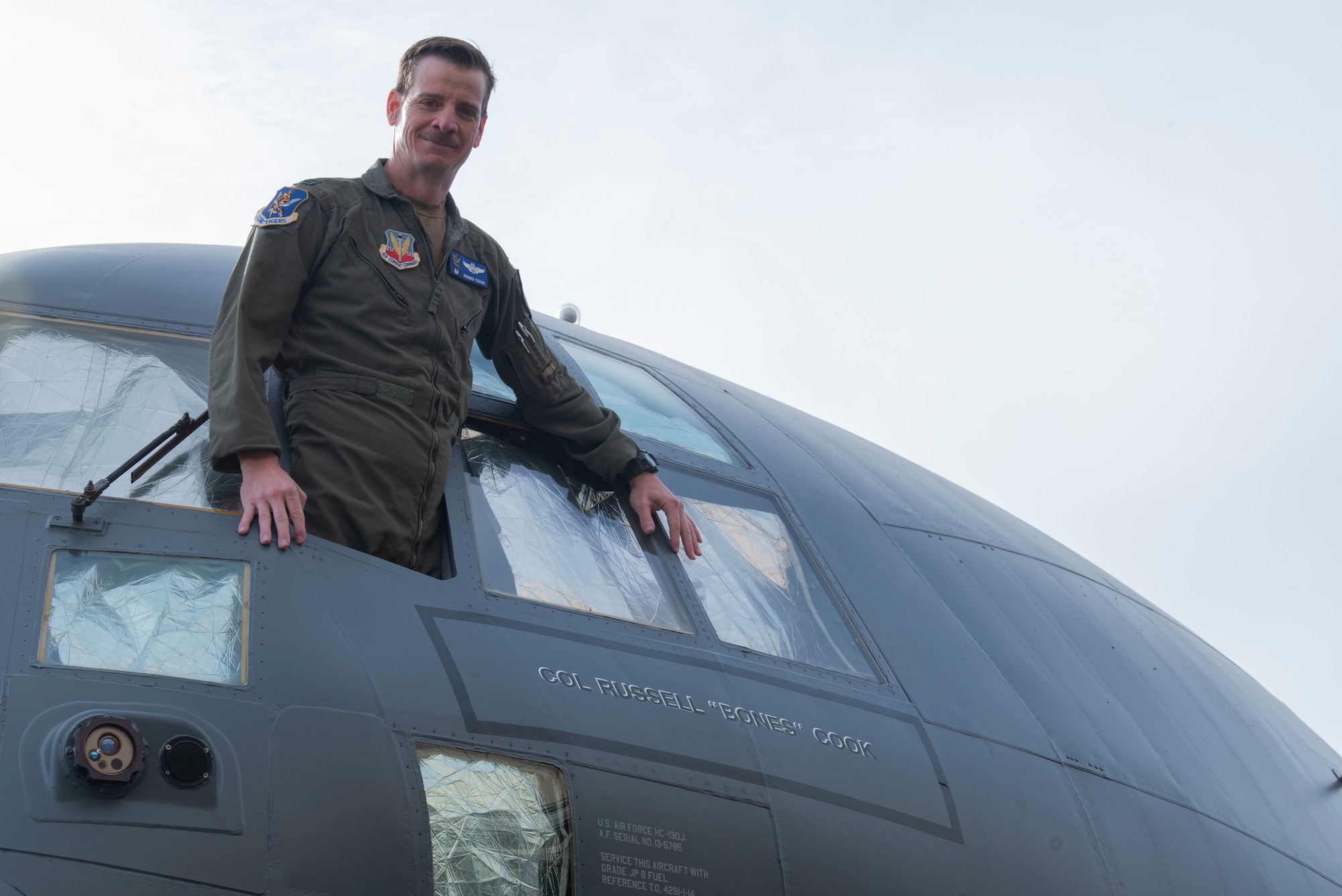 U.S. Air Force Col. Russell “Bones” Cook, 23rd Wing commander, stands to show his name on the side of the 23rd Wing Flagship during a dedication ceremony at Moody Air Force Base, Georgia, March 30, 2022. HC-130J Combat King II 13-5785 was dedicated as the 23rd Wings Flagship, and given a unique paint job, as well as the commander's name on its side. (U.S. Air Force photo by Senior Airman Thomas Johns)