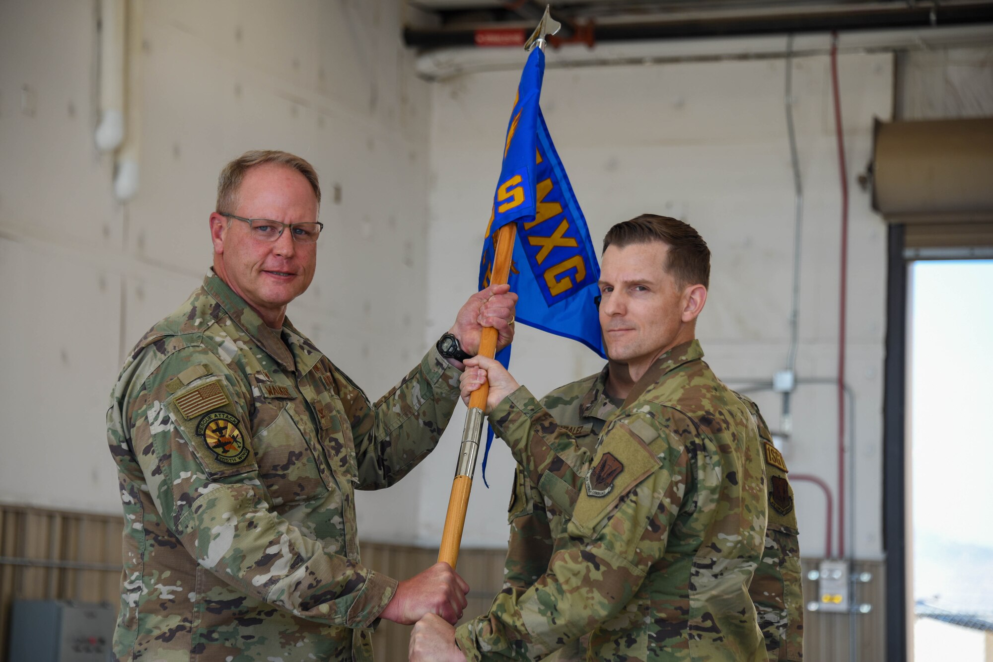 A photo of two Airmen holding a squadron guidon.