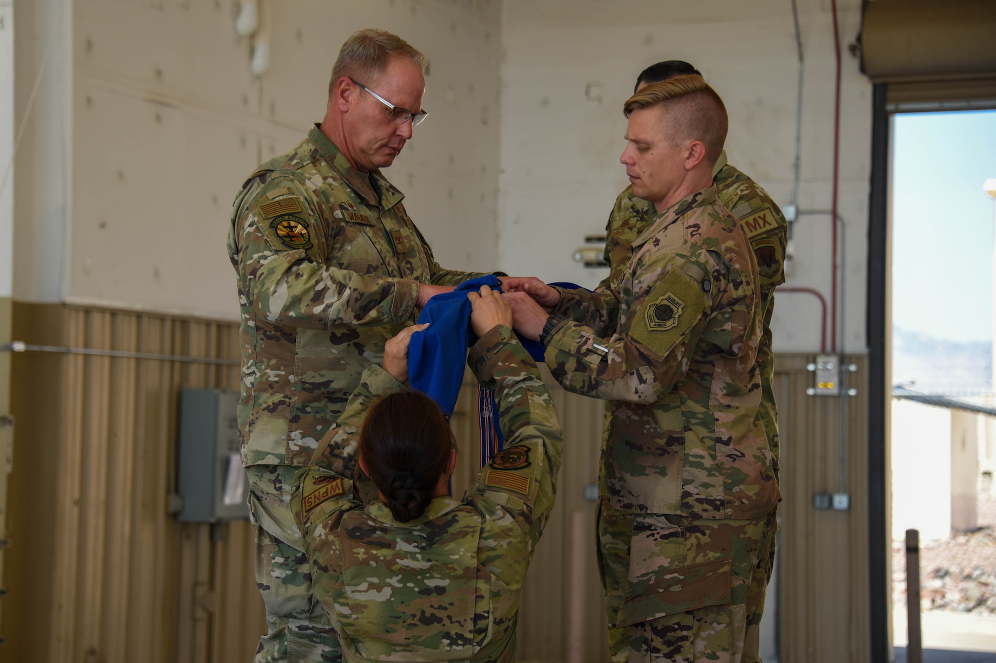 A photo of Airmen casing the squadron guidon.