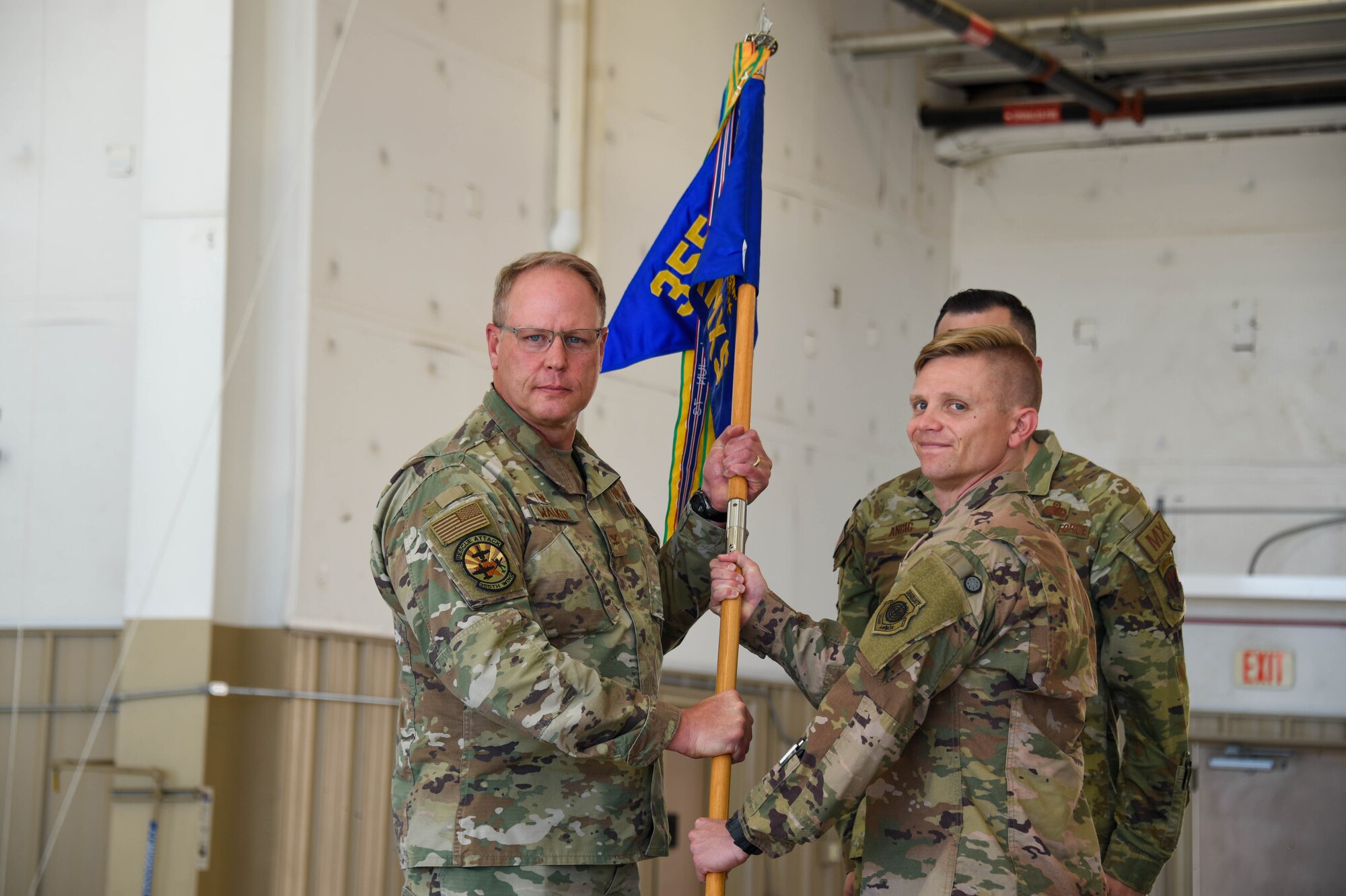 A photo of two Airmen holding a guidon.