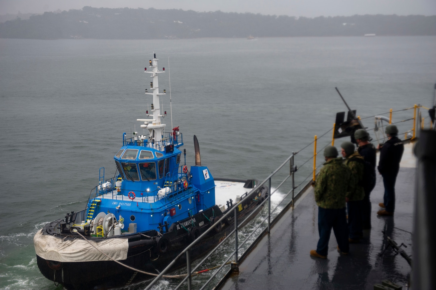 SYDNEY (April 6, 2022) – A tugboat tied alongside the Emory S. Land-class submarine tender USS Frank Cable (AS 40), leads the ship out of the harbor as the ship departs Sydney, Australia, April 6. Frank Cable is currently on patrol conducting expeditionary maintenance and logistics in support of national security in the U.S. 7th Fleet area of operations.