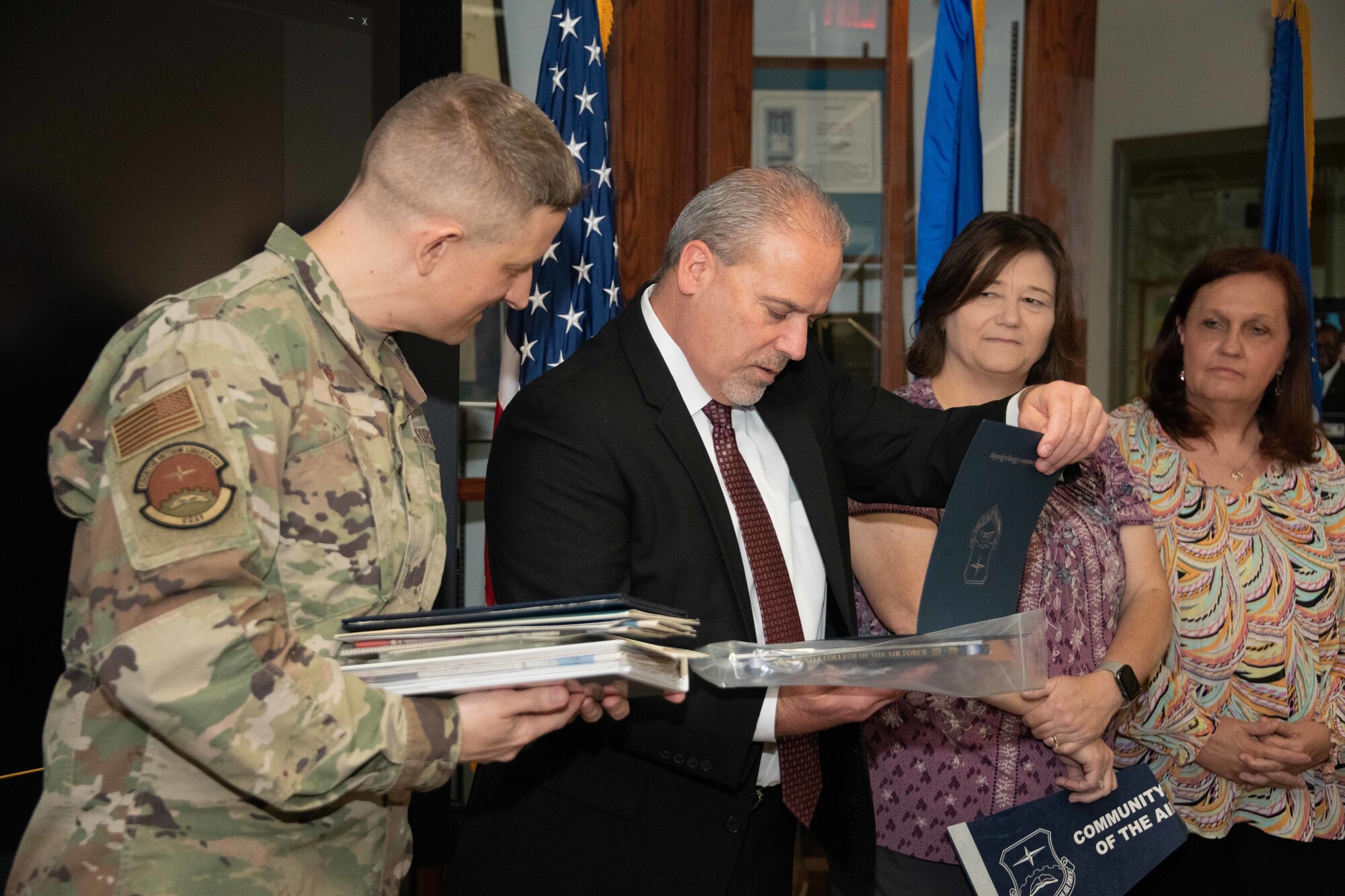 Lt. Col. Kevin Pond, Community College of the Air Force commandant, and staff members gather to open the CCAF time capsule in honor of its 50th anniversary at Maxwell Air Force Base, Ala., April 1, 2022. (U.S. Air Force photo by Melanie Rodgers Cox)