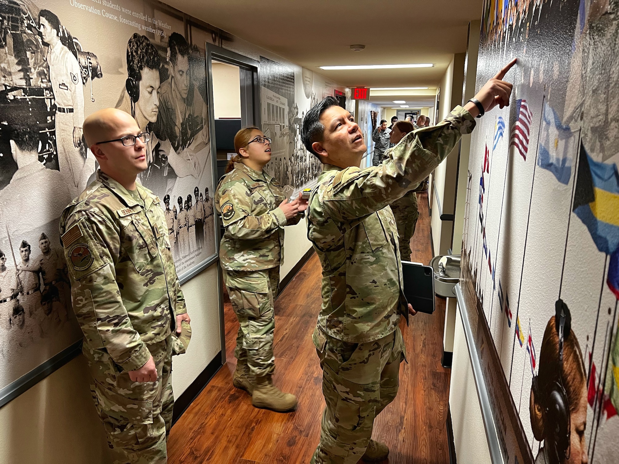 IAAFA staff look at photos on heritage wall