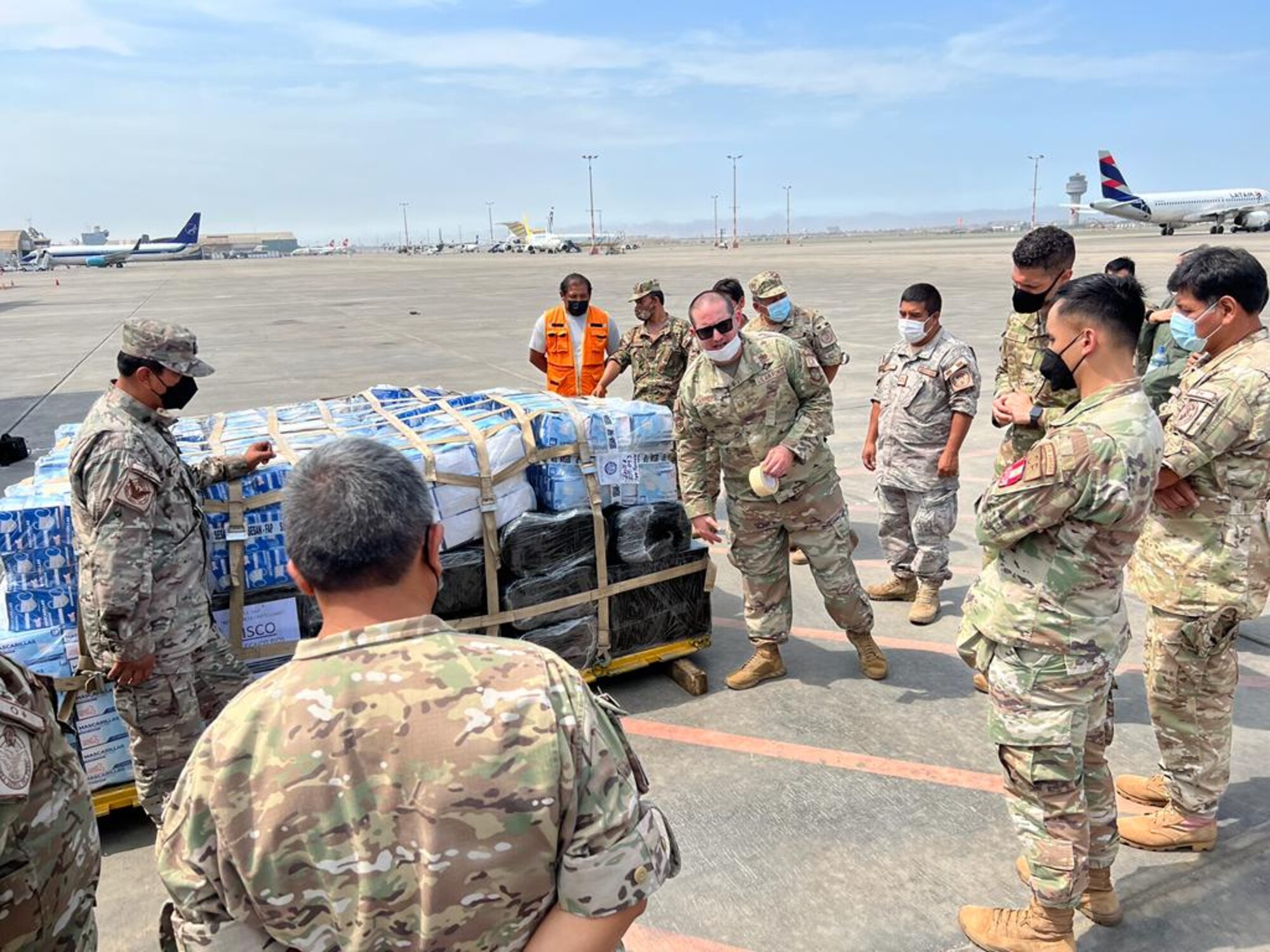 Tech. Sgt. Bruno Carreiro, center, 571st Mobility Support Advisory Squadron air advisor, instructs Peruvian Air Force loadmasters on pallet build-up March 2, 2022, at Callao Air Base, Lima, Peru. The training was developed to improve the effectiveness on PERAF’s operational capabilities by reducing loading times by 50 percent. (Courtesy photo)