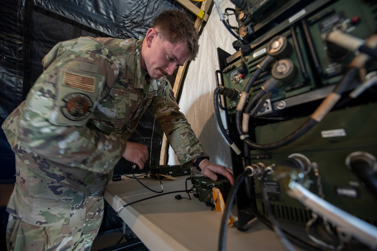Airman plugs in radio wires.