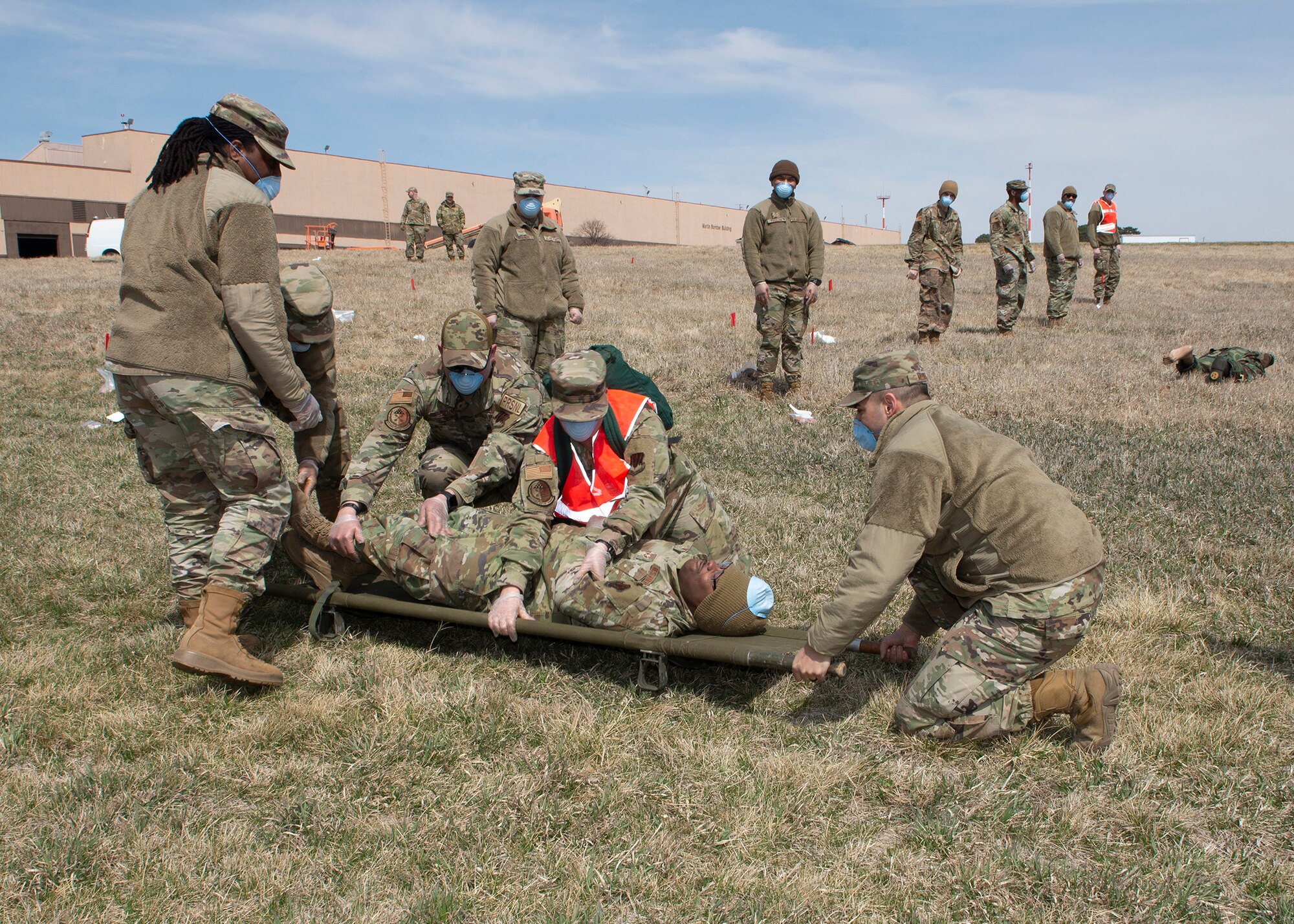 a group of airmen in uniform place and Airmen on a stretcher