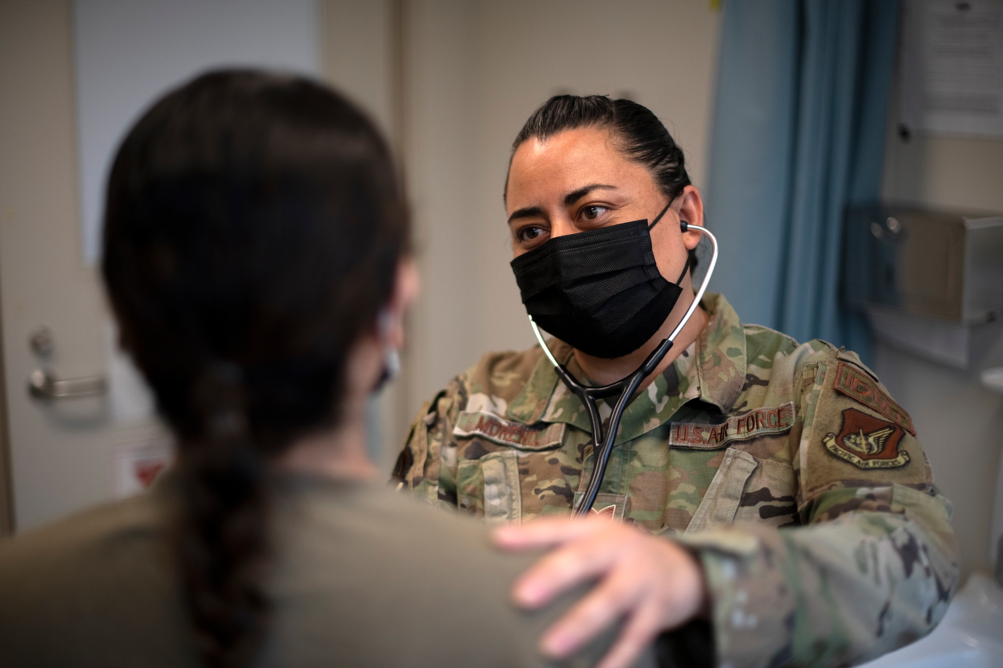 U.S. Air Force Staff Sgt. Linda Moreno, an independent duty medical technician assigned to the 44th Fighter Squadron, consults with a patient at Kadena Air Base, Japan, April 4, 2022.  Before joining the Air Force, Moreno worked as a civilian emergency medical technician. (U.S. Air Force photo by Senior Airman Jessi Monte)