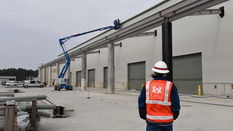 U.S. Army Corps of Engineers, Europe District Project Engineer McCabe Stanley checks progress on the exterior of one of several facilities being built as part of the ongoing Army Prepositioned Stock construction efforts in Powidz, Poland March 17, 2022. The APS project involves the construction of a series of humidity-controlled warehouses and other associated facilities to allow for the storage and maintenance of military vehicles and equipment and is the largest project in Poland being managed by Europe District’s Northern Europe Area Office. (U.S. Army photo by Chris Gardner)