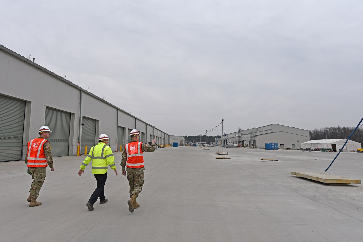 U.S. Army Corps of Engineers, Europe District Deputy Commander Lt. Col. Dan Fox, Europe District Senior Project Engineer James O’Riley and U.S. Army Corps of Engineers Commander Lt. Gen. Scott Spellmon walk through the site of the ongoing Army Prepositioned Stock construction efforts in Powidz, Poland March 17, 2022. The APS project involves the construction of a series of humidity-controlled warehouses and other associated facilities to allow for the storage and maintenance of military vehicles and equipment and is the largest project in Poland being managed by Europe District’s Northern Europe Area Office. (U.S. Army photo by Chris Gardner)