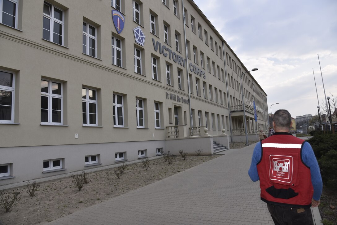 U.S. Army Corps of Engineers, Europe District Area Engineer August Carrillo walks by offices for the U.S. Army’s V Corps on the Polish Army base in Poznan, Poland March 16, 2022. The Polish Army shares the facility and recently completed overall exterior renovations and interior renovations of the portion used by Polish personnel and Europe District is in the planning stages for renovating the interior portion of the facility where U.S. personnel will work. (U.S. Army photo by Chris Gardner)