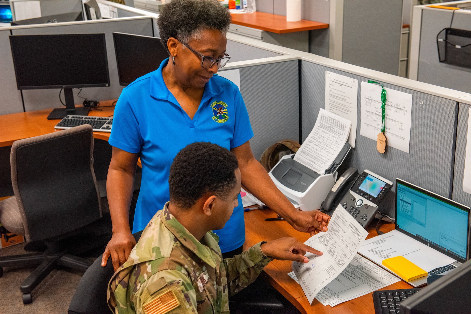 U.S. Air Force Senior Airman Miles Clark, 23rd Comptroller Squadron accounting technician, and Sheila Carter, 23rd CPTS budget analyst, review paperwork at Moody Air Force Base, Georgia, April 7, 2022. While maintaining the normal routine for 23rd wing operations, the CPTS team went outside its normal scope by developing a plan to make Lead-Wing readiness a reality. (U.S. Air Force photo by Airman 1st Class Courtney Sebastianelli)