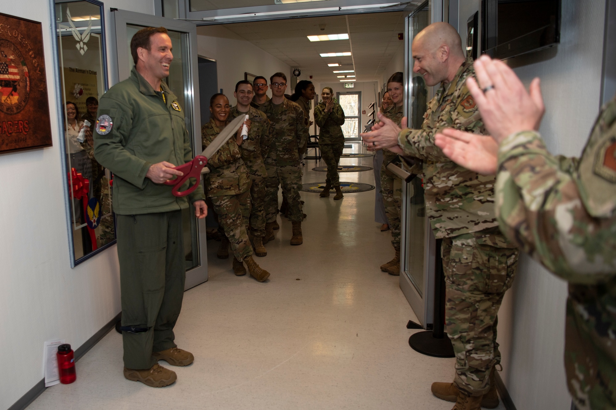 U.S. Air Force Col. Leslie Hauck, 52nd Fighter Wing commander, left, and Chief Master Sgt. Toby Roach, 52nd FW command chief, participate in a ribbon cutting ceremony for Saber University, Apr. 4, 2022, on Spangdahlem Air Base, Germany.