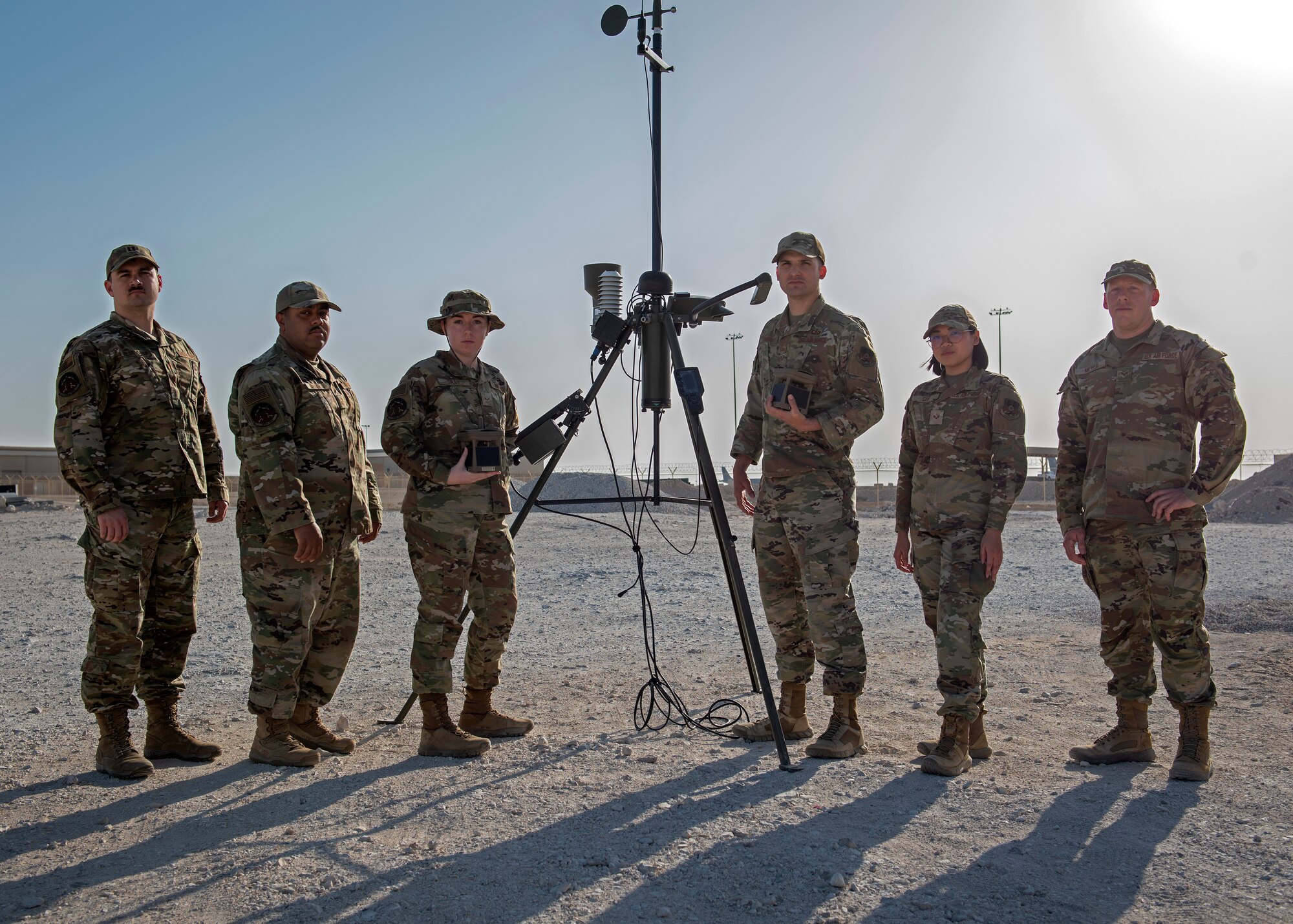photo of an airmen in front of weather reading equipment posing for a group photo