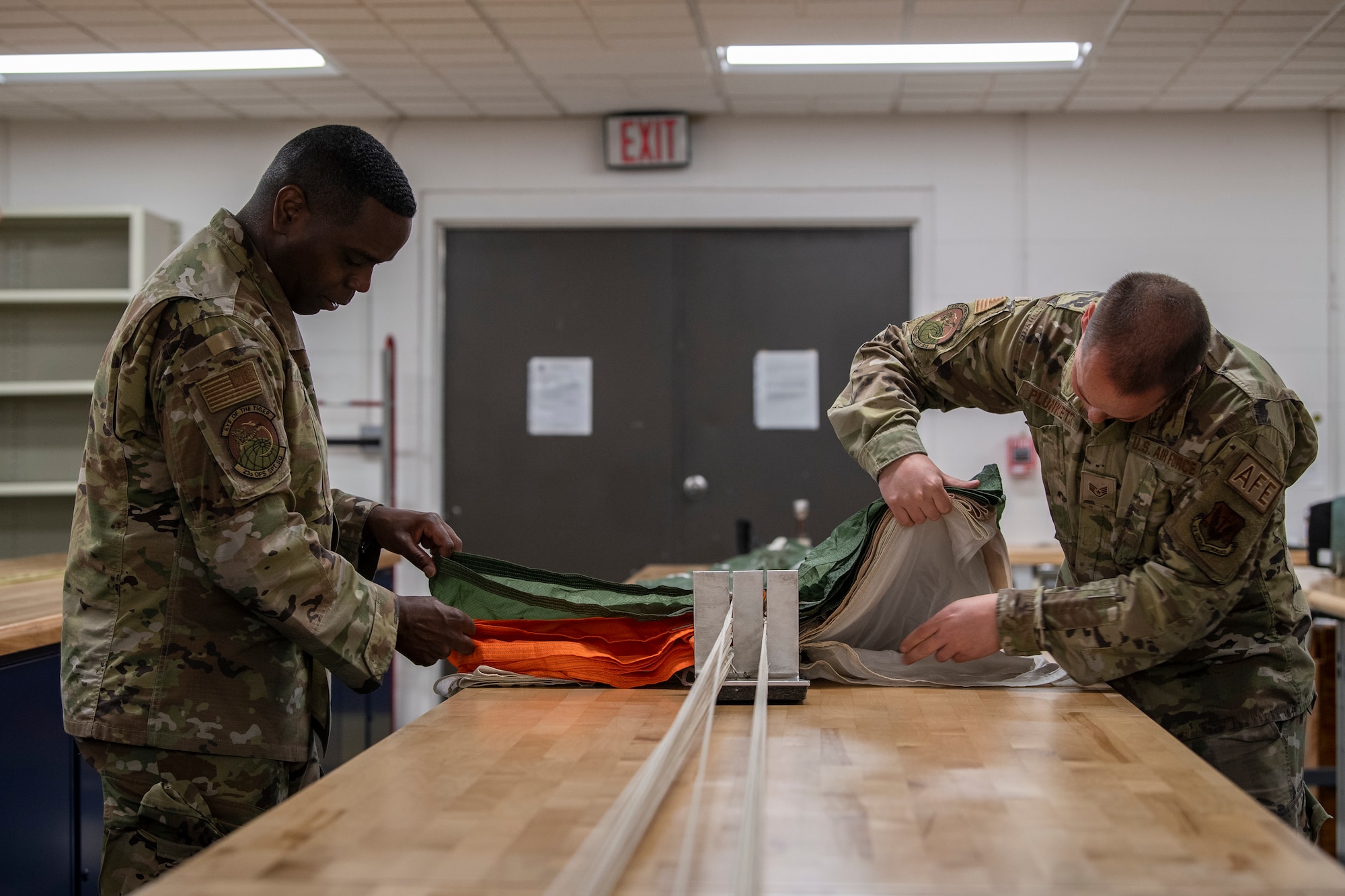 two men packing a parachute