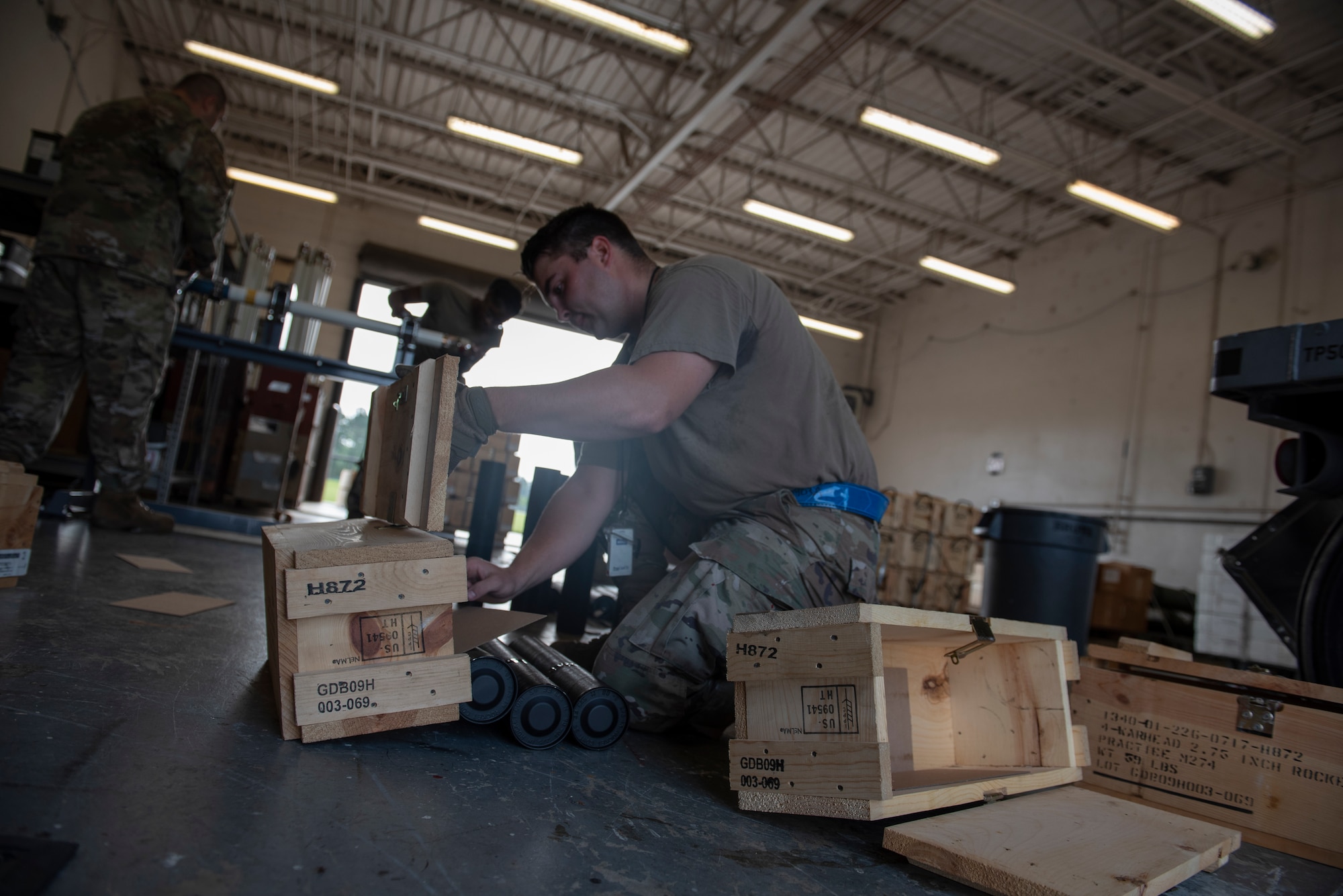 A photo of a person dumping out black tubes from a box onto the floor.