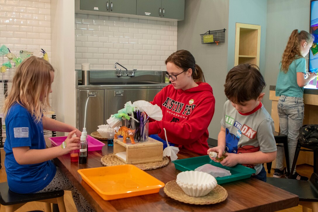 Four children work on arts and craft projects.