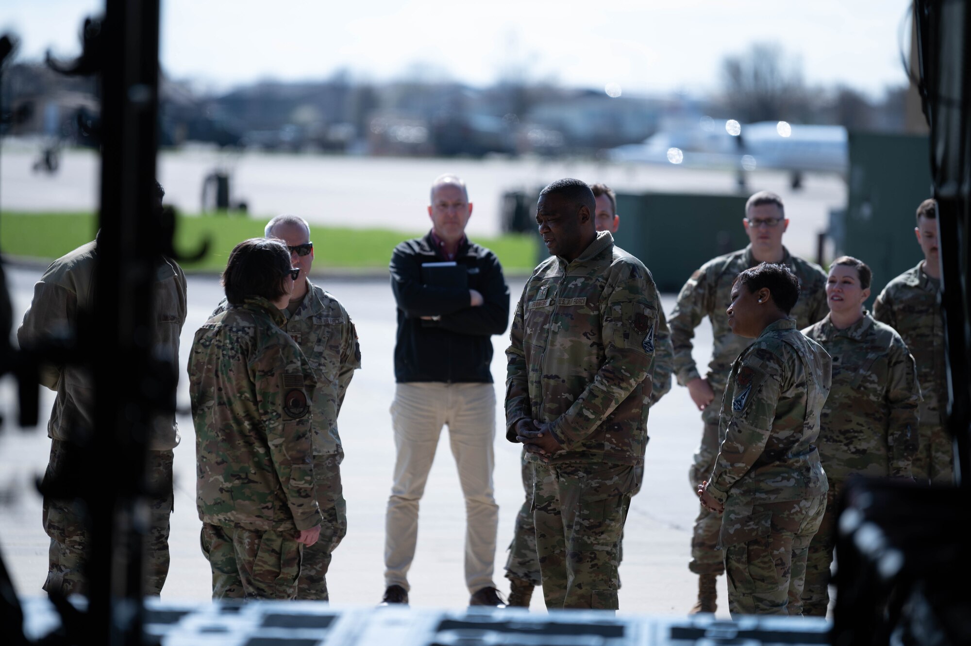 Airmen stand outside of fuselage