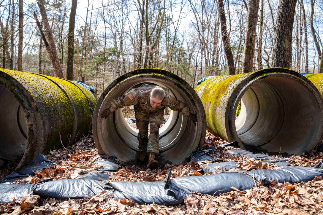 A soldier walks through a tunnel obstacle.