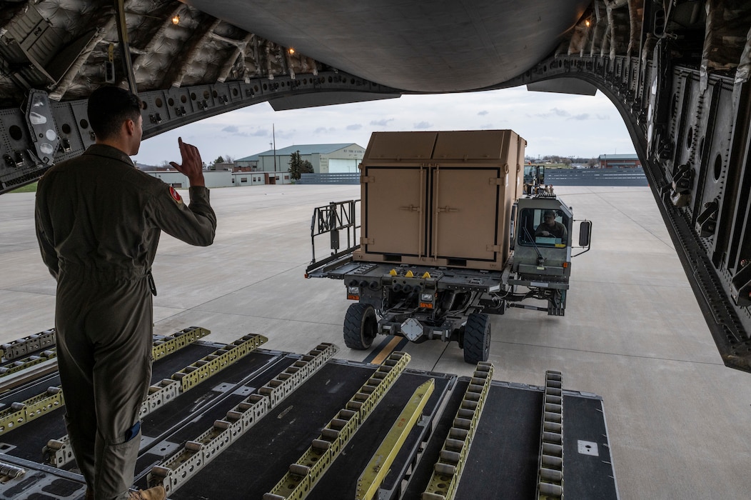 U.S. Air Force Airman 1st Class Eric Flores, a 167th Airlift Wing loadmaster guides a Halvorsen Loader, also known as a 25K loader, closer to the loading ramp of C-17 Globemaster III aircraft during a ground training event, March 31, 2022. Guiding the Halvorsen is one of the fundamental skill sets new loadmasters learn.