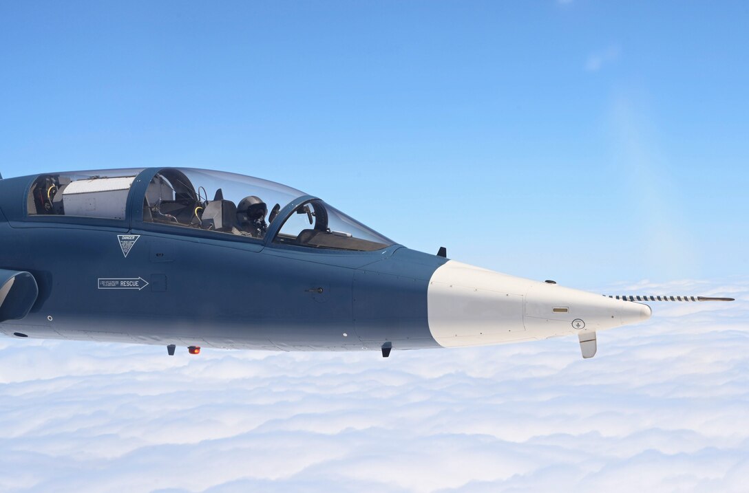 An aircraft flies near clouds.