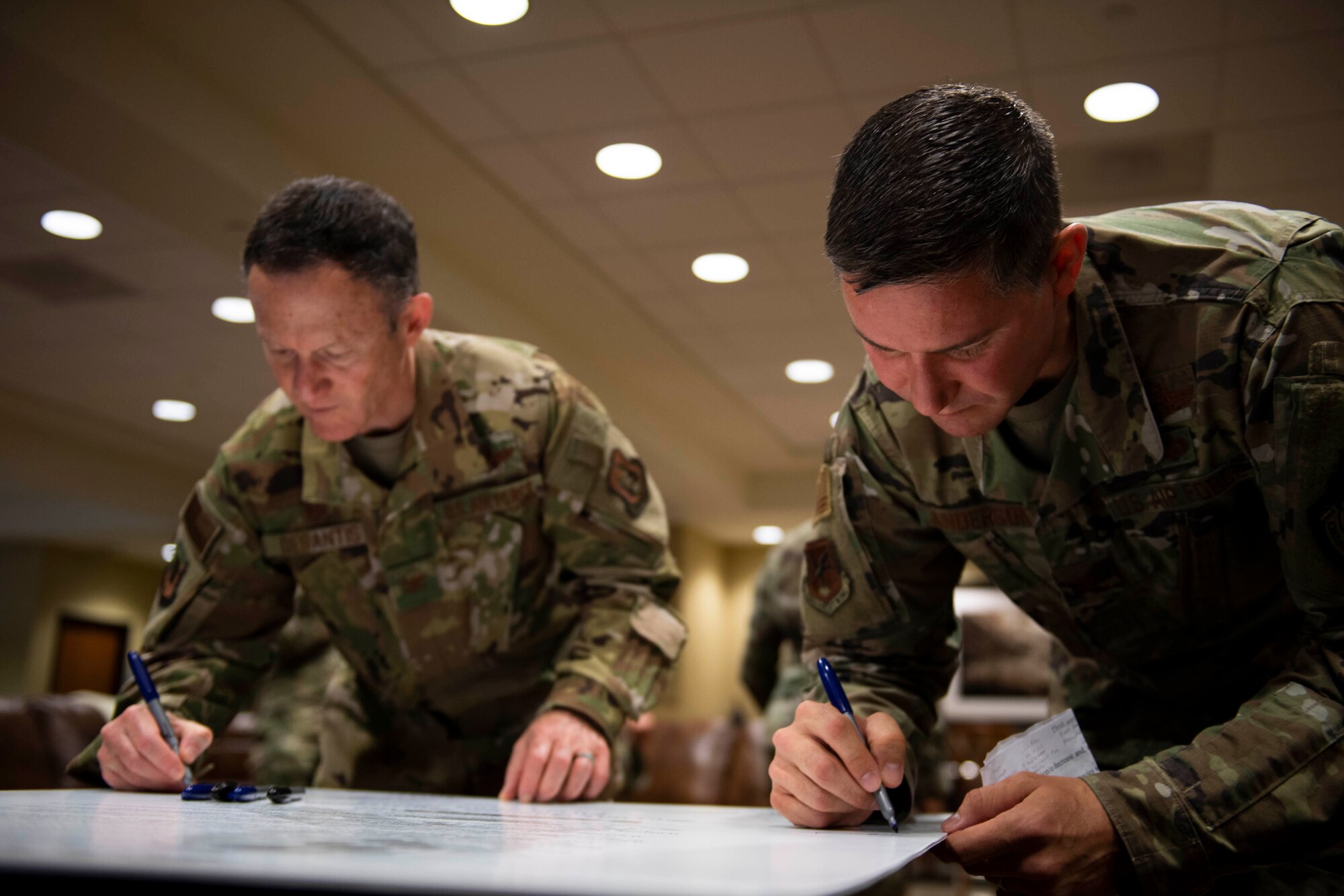 Col. Shanon Anderson, right, 436th Airlift Wing vice commander, and Col. Michael DeSantis 512th Operations Group commander, sign the Sexual Assault Awareness Month proclamation at Dover Air Force Base, Delaware, April 1, 2022. Anderson and DeSantis, along with other Dover AFB senior leaders, signed the proclamation to support SAAM in April. (U.S. Air Force photo by Tech. Sgt. J.D. Strong II)