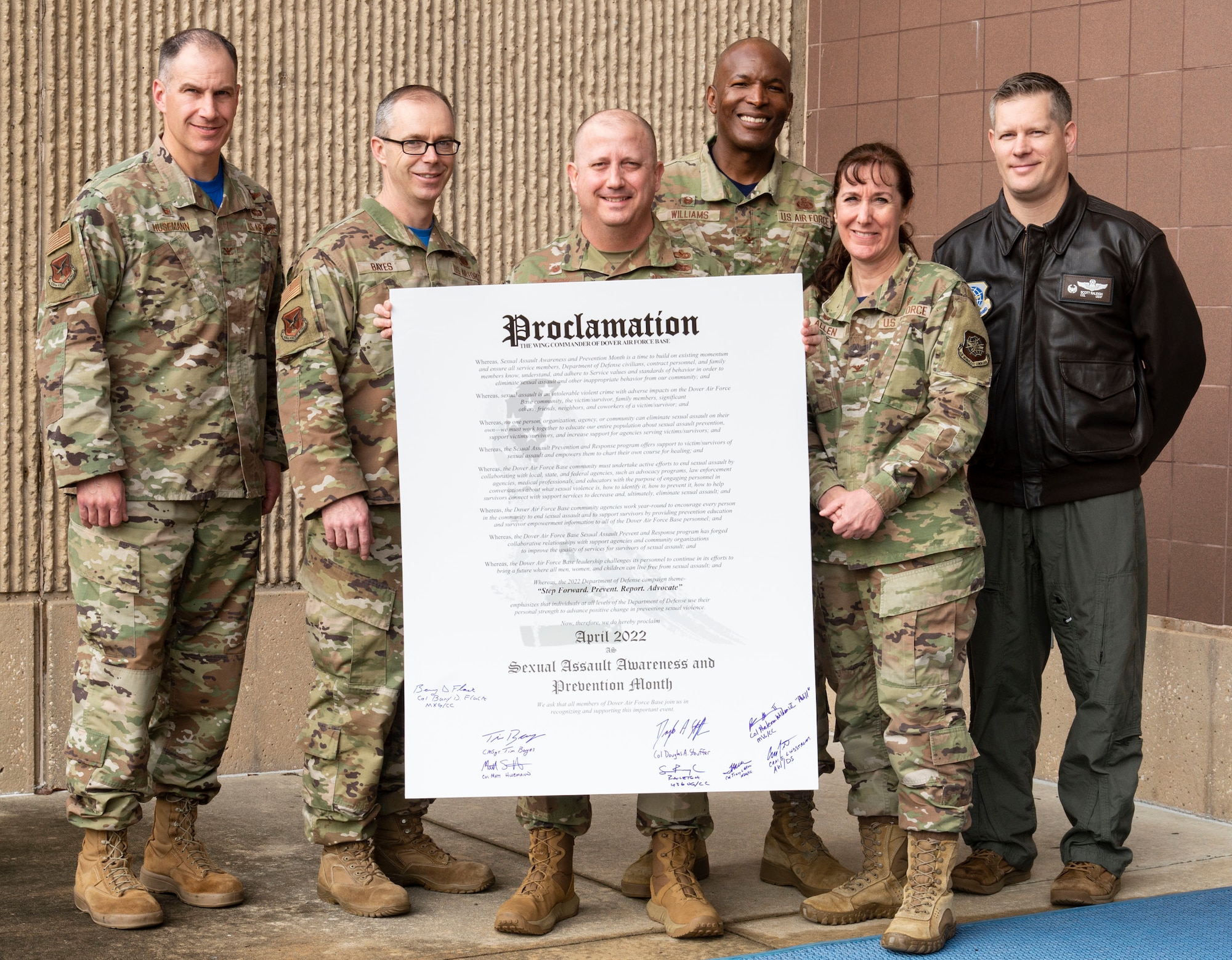 From the left, Col. Matt Husemann, 436th Airlift Wing commander; Chief Master Sgt. Timothy Bayes, 436th AW command chief; Col. Bary Flack, 436th Maintenance Group commander; Col. Phelemon Williams, 436th Mission Support Group commander; Col. Tracy Allen, 436th Medical Group commander; and Col. Scott Raleigh, 436th Operations Group commander; stand by the 2022 Sexual Assault Awareness Month proclamation at Dover Air Force Base, Delaware, March 25, 2022. Husemann, Bayes and the group commanders signed the proclamation to support SAAM in April. (U.S. Air Force photo by Roland Balik)