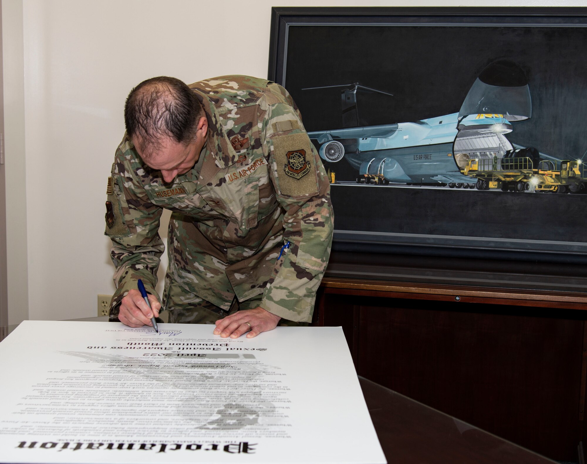 Col. Matt Husemann, 436th Airlift Wing commander, signs the Sexual Assault Awareness Month proclamation at Dover Air Force Base, Delaware, March 14, 2022. Husemann, along with other Dover AFB senior leaders, signed the proclamation to support SAAM in April. (U.S. Air Force photo by Roland Balik)
