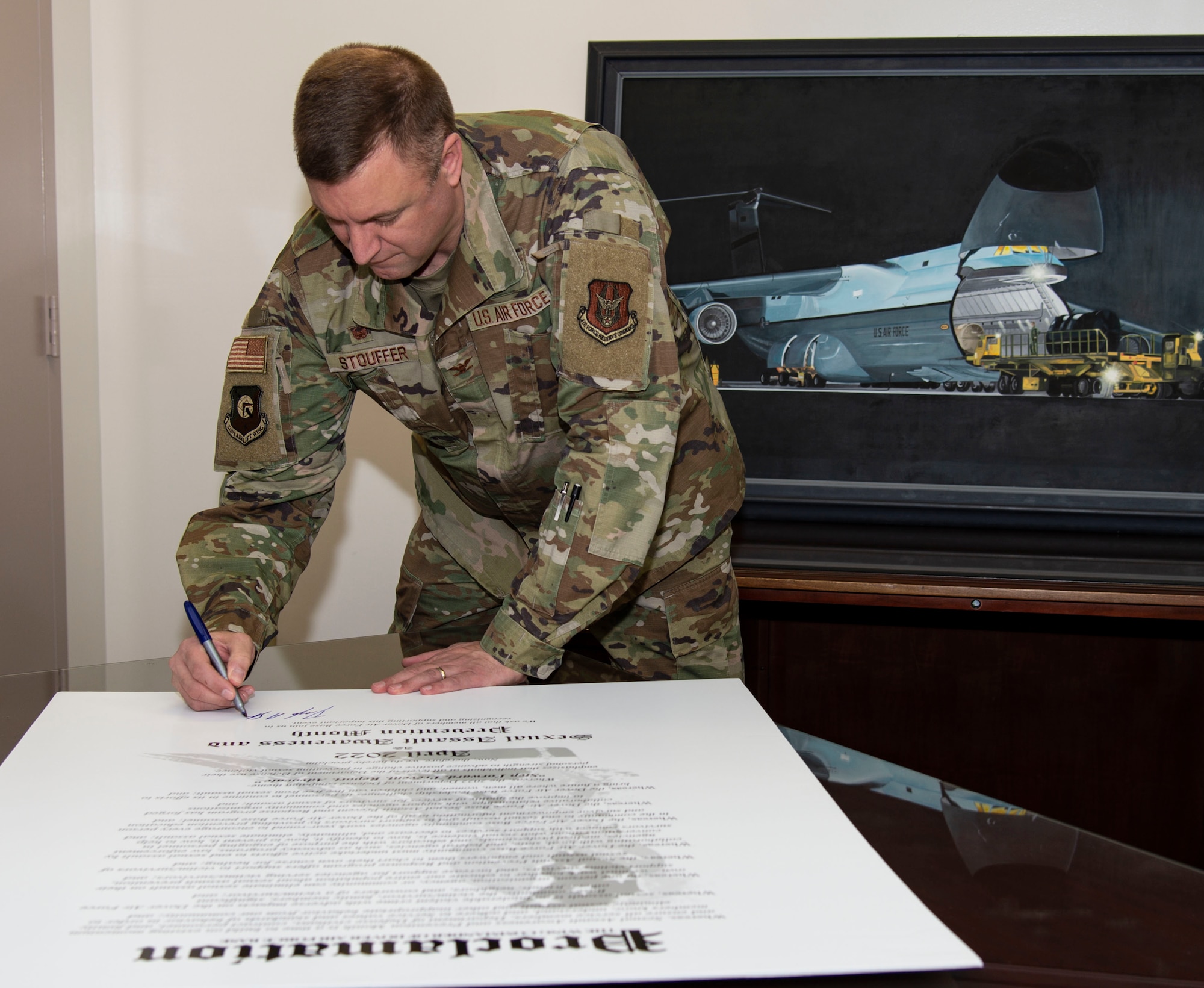 Col. Doug Stouffer, 512th Airlift Wing commander, signs the Sexual Assault Awareness Month proclamation at Dover Air Force Base, Delaware, March 14, 2022. Stouffer, along with other Dover AFB senior leaders, signed the proclamation to support SAAM in April. (U.S. Air Force photo by Roland Balik)