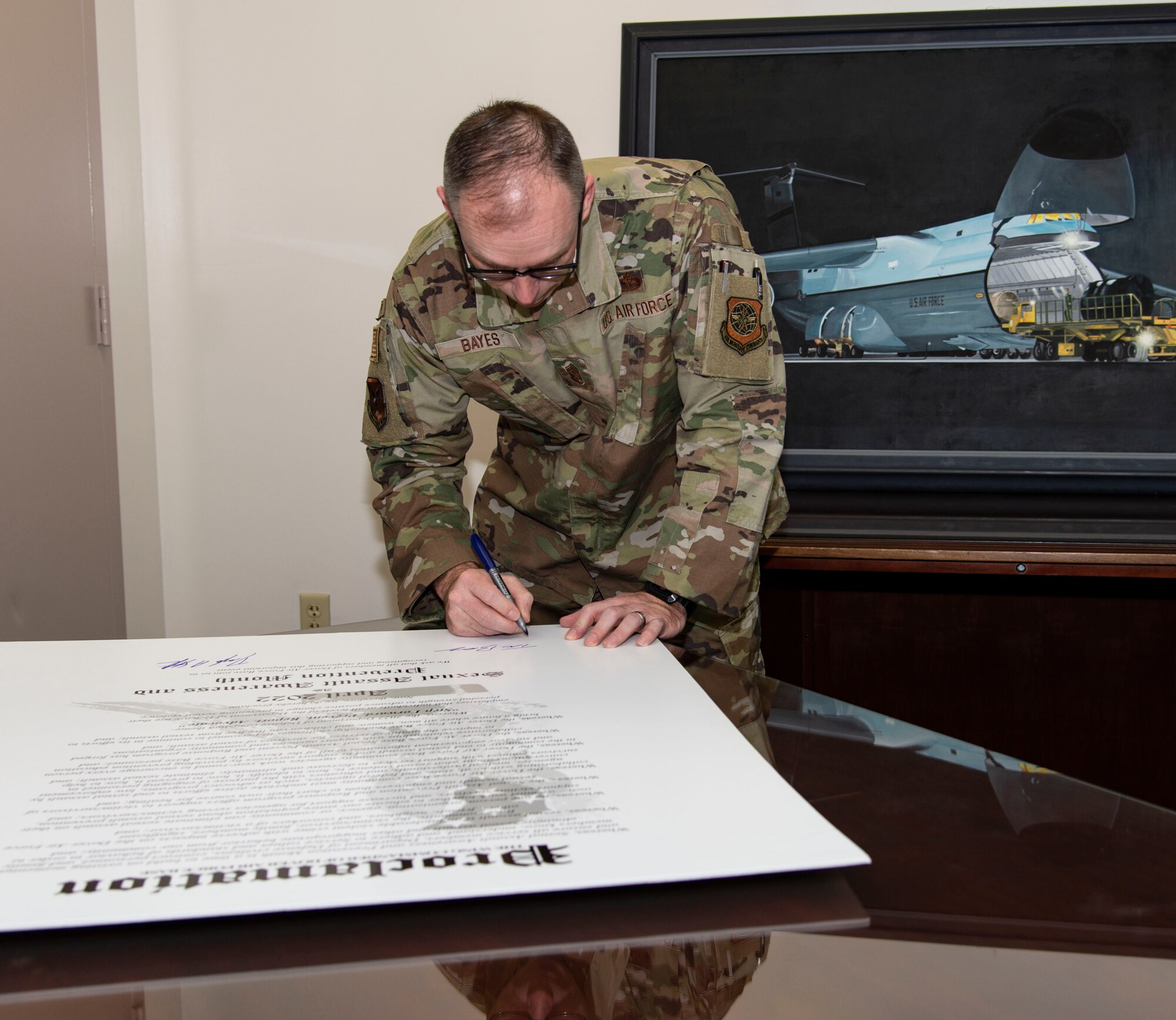 Chief Master Sgt. Timothy Bayes, 436th Airlift Wing command chief, signs the Sexual Assault Awareness Month proclamation at Dover Air Force Base, Delaware, March 14, 2022. Bayes, along with other Dover AFB senior leaders, signed the proclamation to support SAAM in April. (U.S. Air Force photo by Roland Balik)