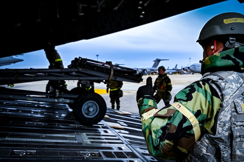 U.S. Air Force Airmen from the 305th Air Mobility Wing wearing mission oriented protective posture gear upload maintenance equipment onto a C-17 Globemaster III, demonstrating the ability to survive and operate in a contested environment during a readiness exercise at Joint Base McGuire-Dix-Lakehurst, New Jersey, Apr. 4, 2022. Training exercises reinforce Airmen readiness and deliberately strengthen Air Mobility Command’s warfighting culture in order to provide unrivaled Rapid Global Mobility capable of protecting and sustaining the Joint Force.
