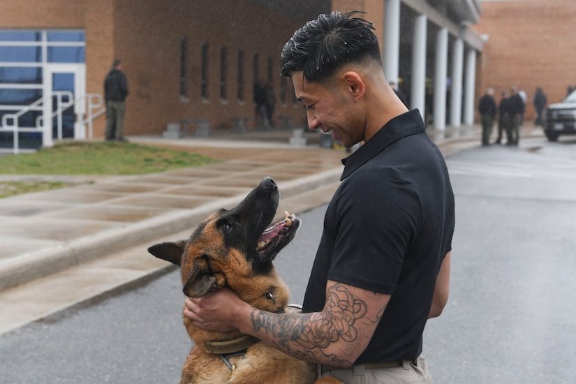 Senior Airman Alistair Dela Cruz, 316th Security Support Squadron military working dog handler, pets MWD Fill prior to the Multi-Agency K-9 Explosive Training Event at Thomas A. Edison High School in Alexandria, Va., Apr. 6, 2022. Handlers attend this training quarterly and the 316th SSPTS tries to send MWD teams who have never attended in the past. (U.S. Air Force photo by Senior Airman Spencer Slocum)