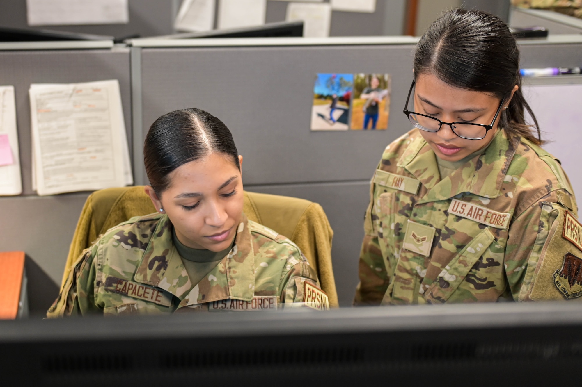 U.S. Air Force Airman 1st Class Vivian Capacete, left, and Airman 1st Class Jan Beatrice Fabay, right, 23rd Force Support Squadron career development technicians, train on procedures and forms, April 5, 2022, at Moody Air Force Base, Georgia. Every few years, Airmen within the Military Personnel Section rotate technical positions after they have mastered one section. (U.S. Air Force photo by Senior Airman Rebeckah Medeiros)