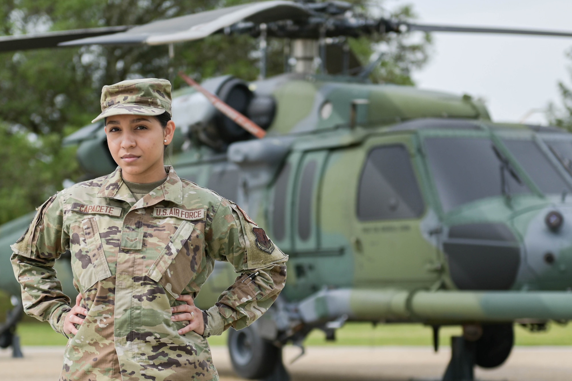 U.S. Air Force Airman 1st Class Vivian Capacete, 23rd Force Support Squadron career development promotions technician, poses in front of an HH-60W Jolly Green II helicopter, April 5, 2022, at Moody Air Force Base, Georgia. The promotions section focuses on testing, Airman Leadership School attendance, reenlistments, retirements and more. (U.S. Air Force photo by Senior Airman Rebeckah Medeiros)