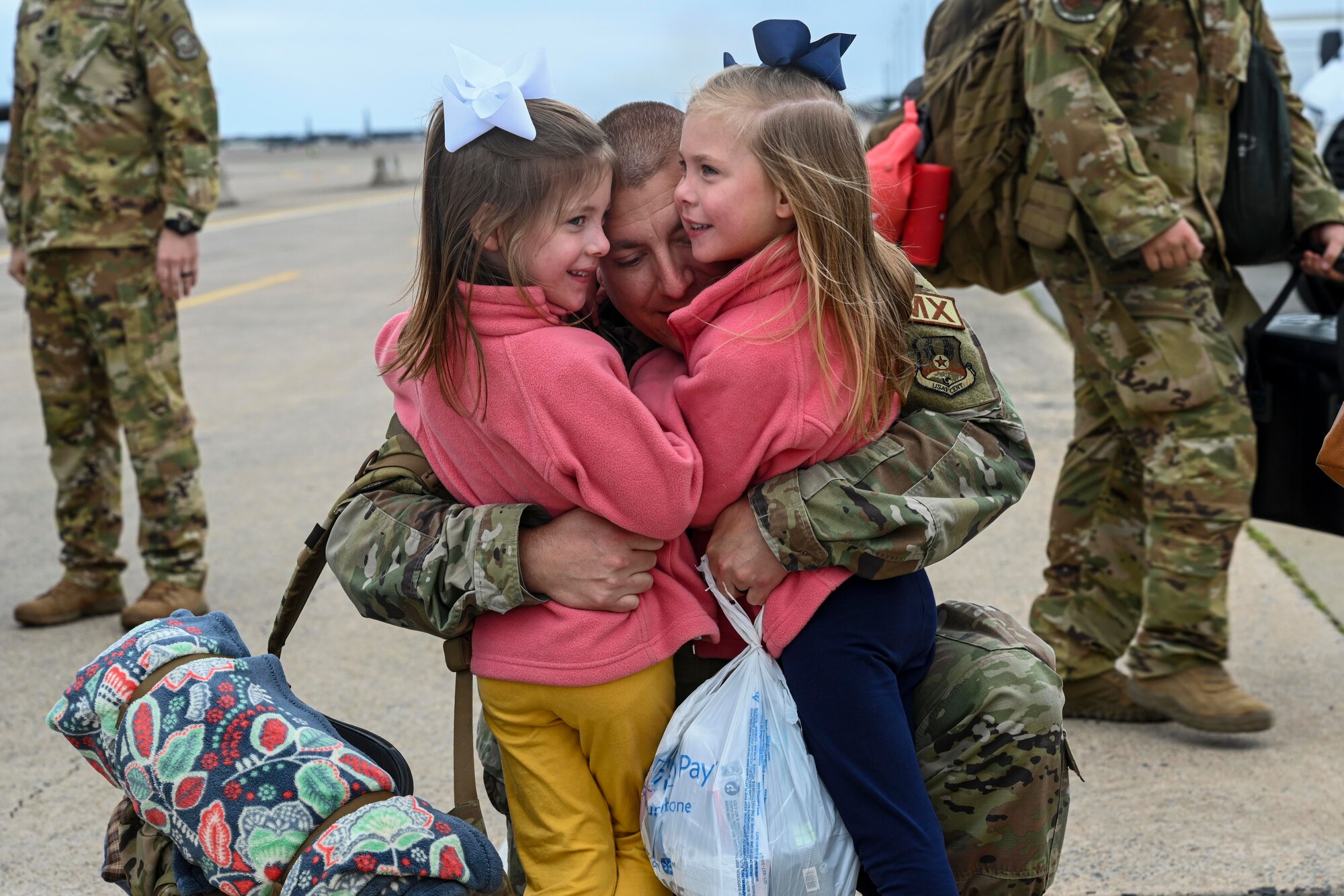 An Airman from the 19th Aircraft Maintenance Squadron reunites with his daughters at Little Rock Air Force Base, Arkansas, after returning from a deployment