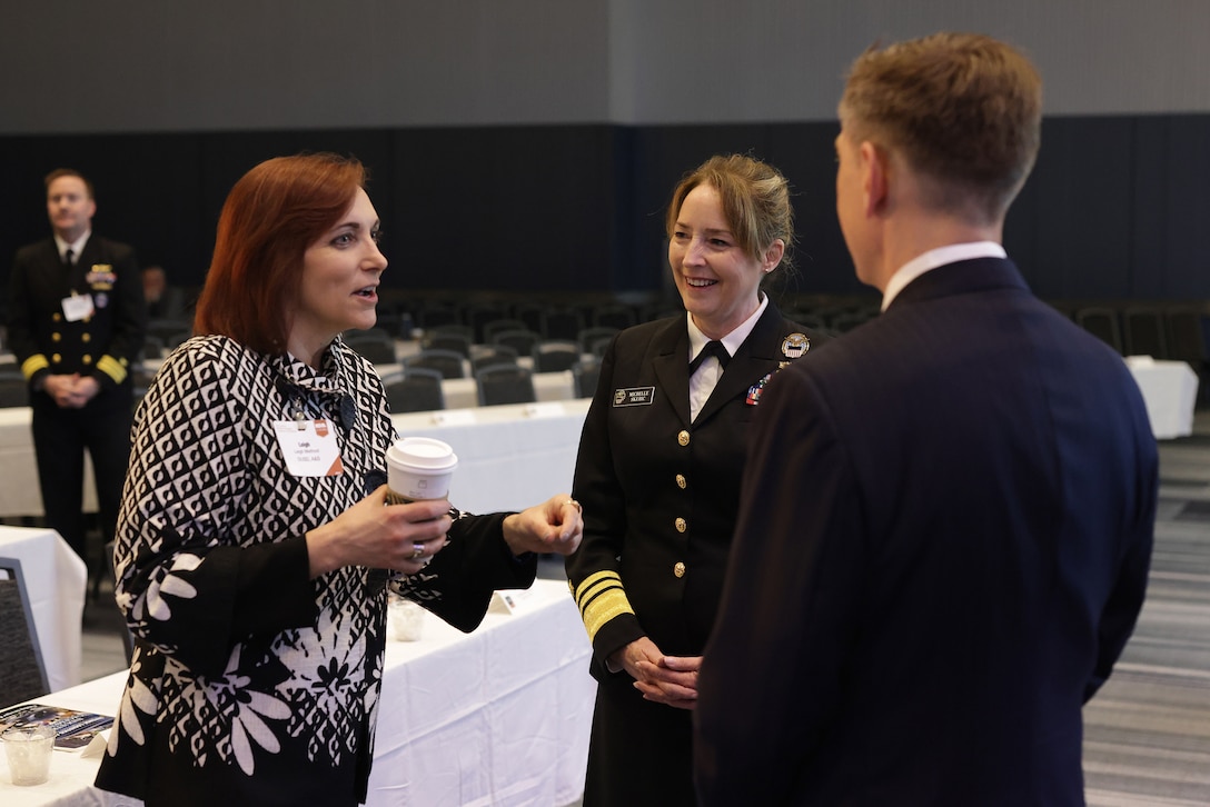 DLA Director Michelle Skubic speaks with two people in an auditorium.