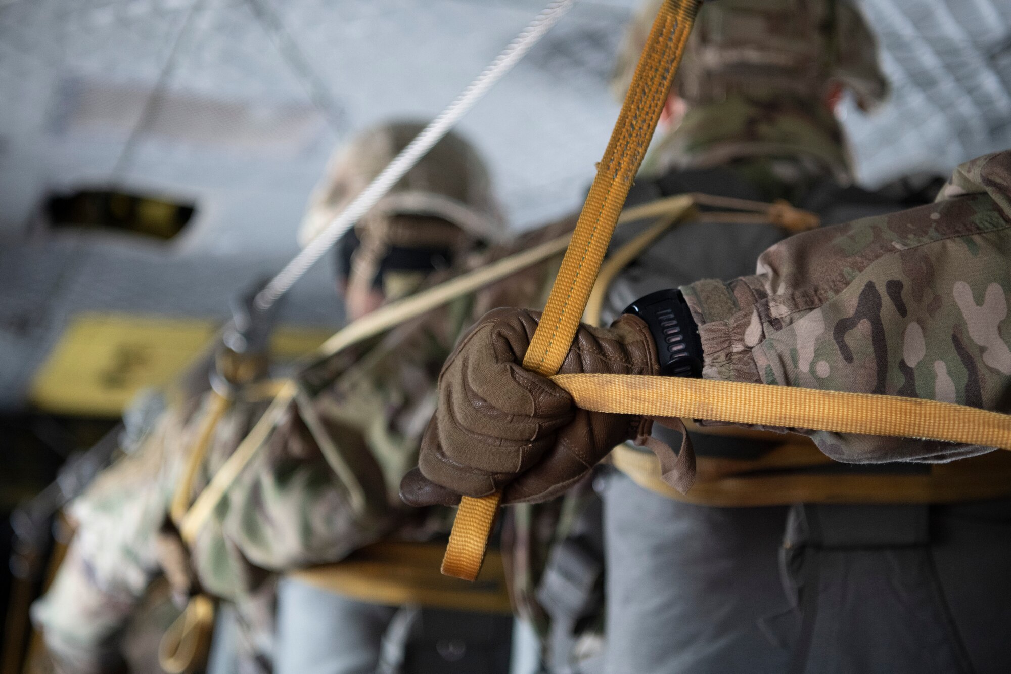 Men hook parachute lines in preparation for a jump