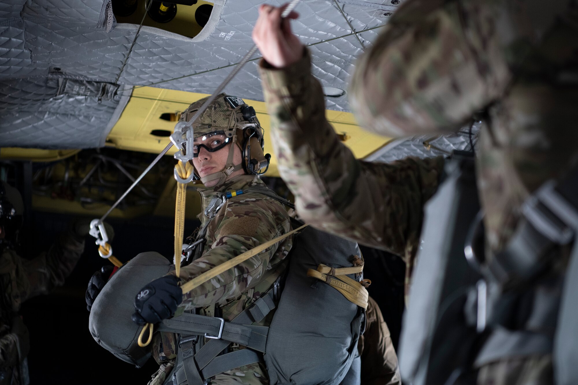 A photo of a man standing to prepare to jump out of a helicopter