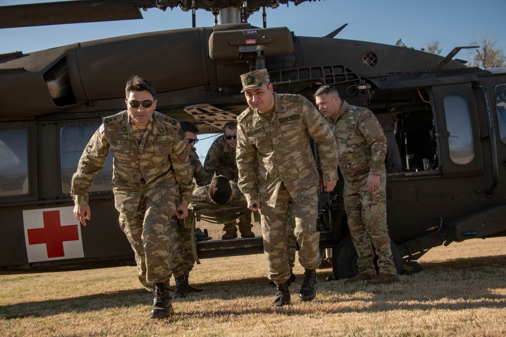 Oklahoma Army National Guard Soldiers and doctors with the Azerbaijan Operational Capabilities Concept Battalion evacuate a simulated patient from a UH-60 Black Hawk helicopter during a medical knowledge exchange in Oklahoma City, April 1, 2022. The Oklahoma Army and Air National Guard participated in support of the Department of Defense National Guard Bureau State Partnership Program.