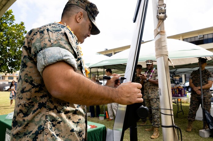 U.S. Marine Corps Col. Speros Koumparakis, commanding officer, Marine Corps Base Hawaii, signs a new proclamation concerning alcohol awareness during the 2022 MCBH Alcohol Awareness Proclamation Signing, MCBH, April 1, 2022. MCBH leadership and Marine Corps Community Services employees  met to sign a new alcohol awareness proclamation into effect, in effort to change attitudes towards alcohol use. (U.S. Marine Corps photo by Cpl. Brandon Aultman)