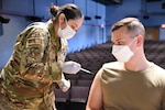 Senior Airman Carmen Gerda, 162nd Medical Squadron, aerospace medical technician, administers the COVID-19 vaccine to a service member at Davis-Monthan Air Force Base, Tucson, Arizona, May 6, 2021.